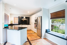 White Kitchen with Feature Black Countertops and Splashback
