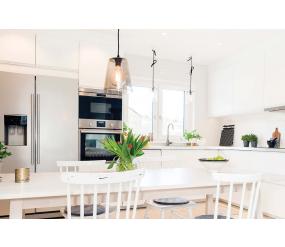 Modern white kitchen space with stainless steel appliances and accessories