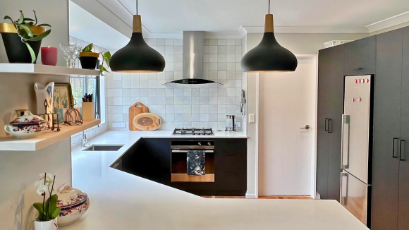 white stone counter black kitchen doors